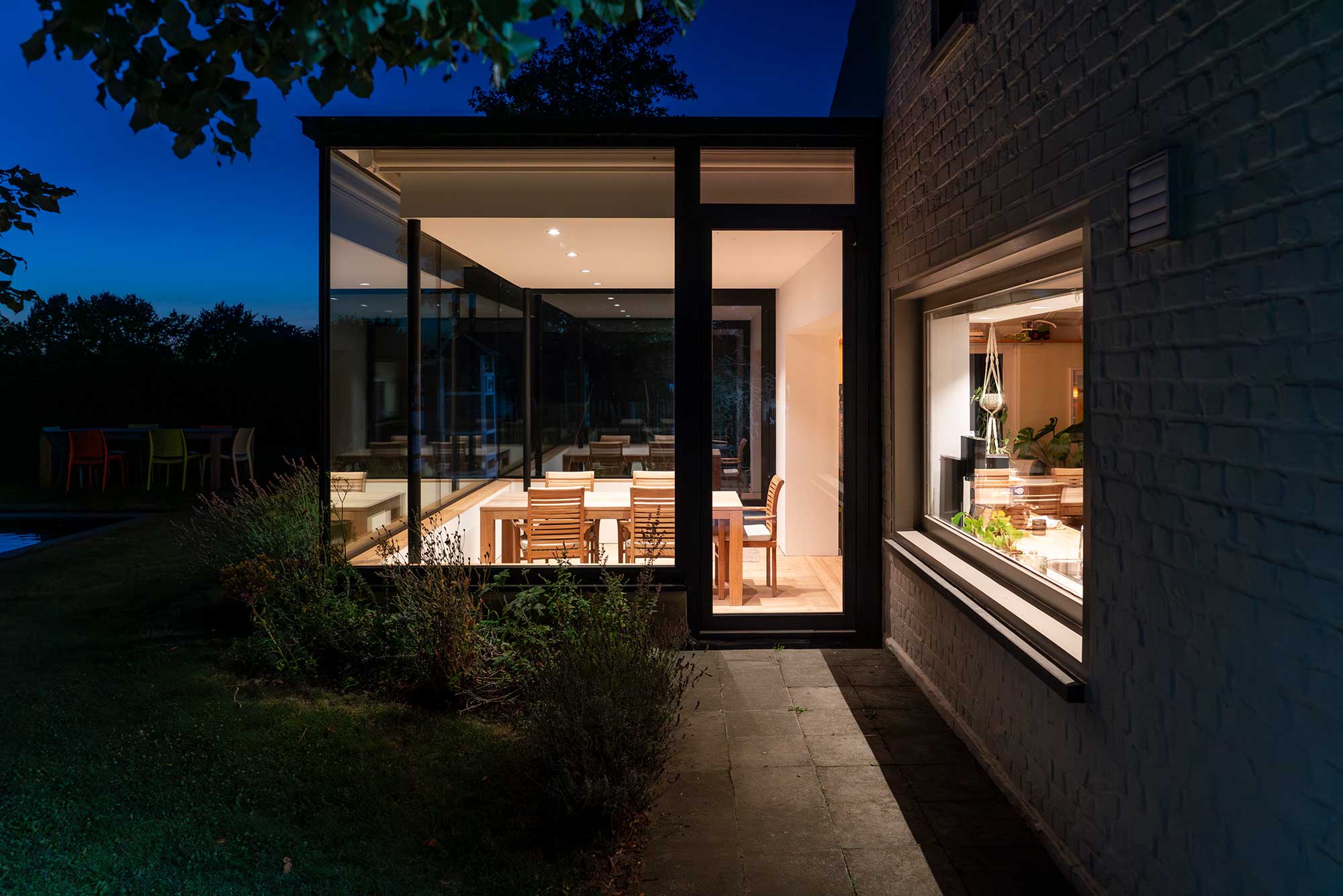 Eine Frau sitzt im Schneidersitz auf dem Sofa vor dem Laptop.