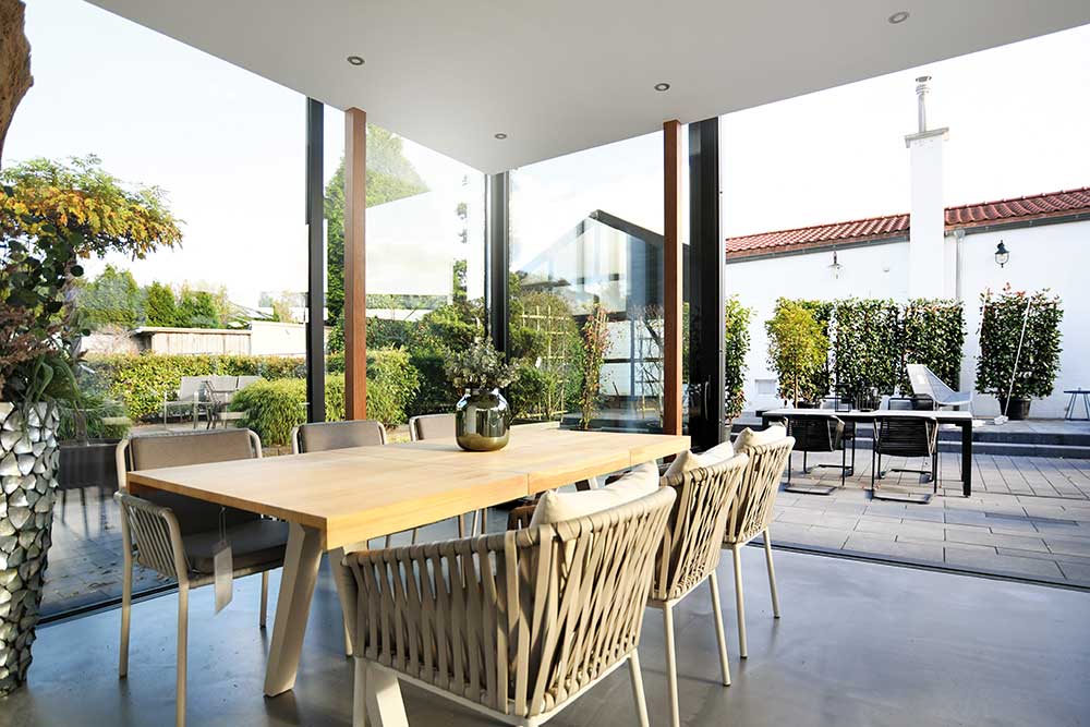 Heller, moderner Essbereich in Mülheim mit großem Holztisch, bequemen Stühlen und Blick in den grünen Garten.